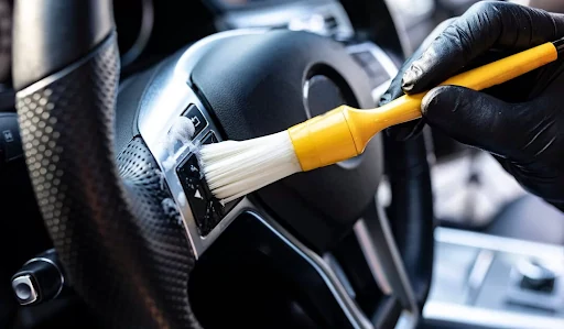 A soft detailing brush cleaning around steering-wheel controls